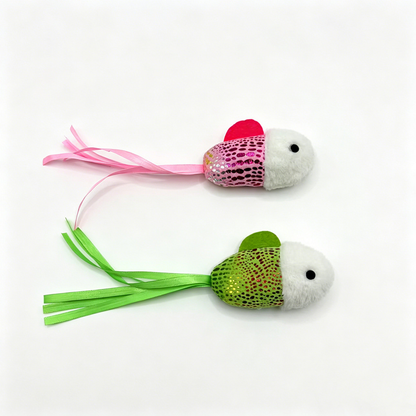 Pink and green fish-shaped cat toys displayed side by side with ribbon tails