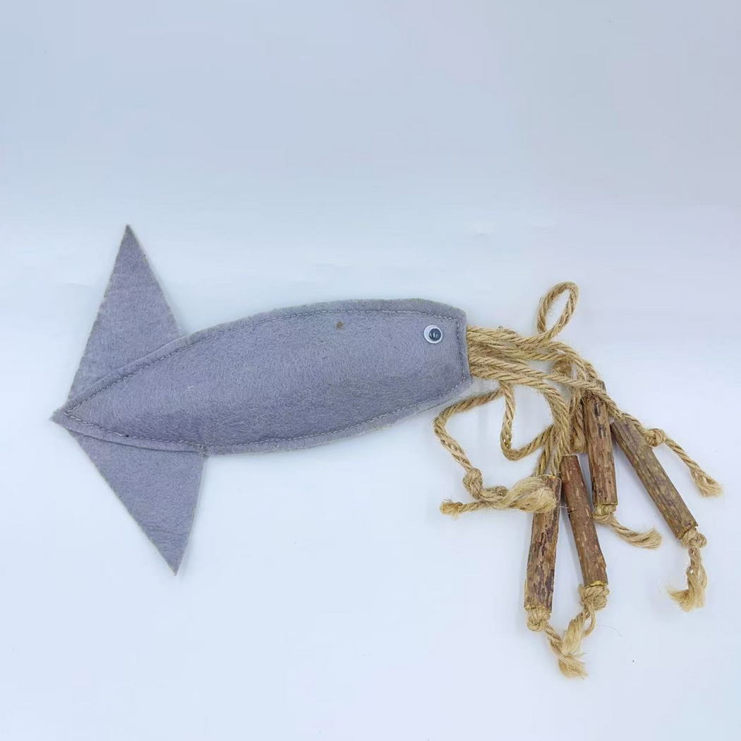 Fish cat toy with a gray blue body, triangular tail, round eye and tan cords with brown sticks