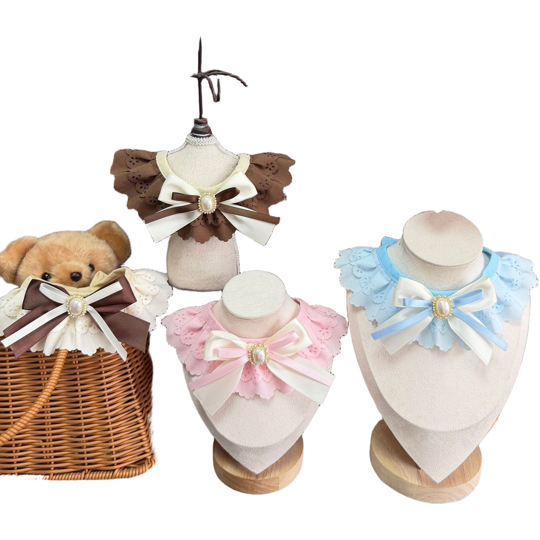 Brown, Ivory, Pink and Blue Pet Neckwear arranged on display forms and a teddy bear