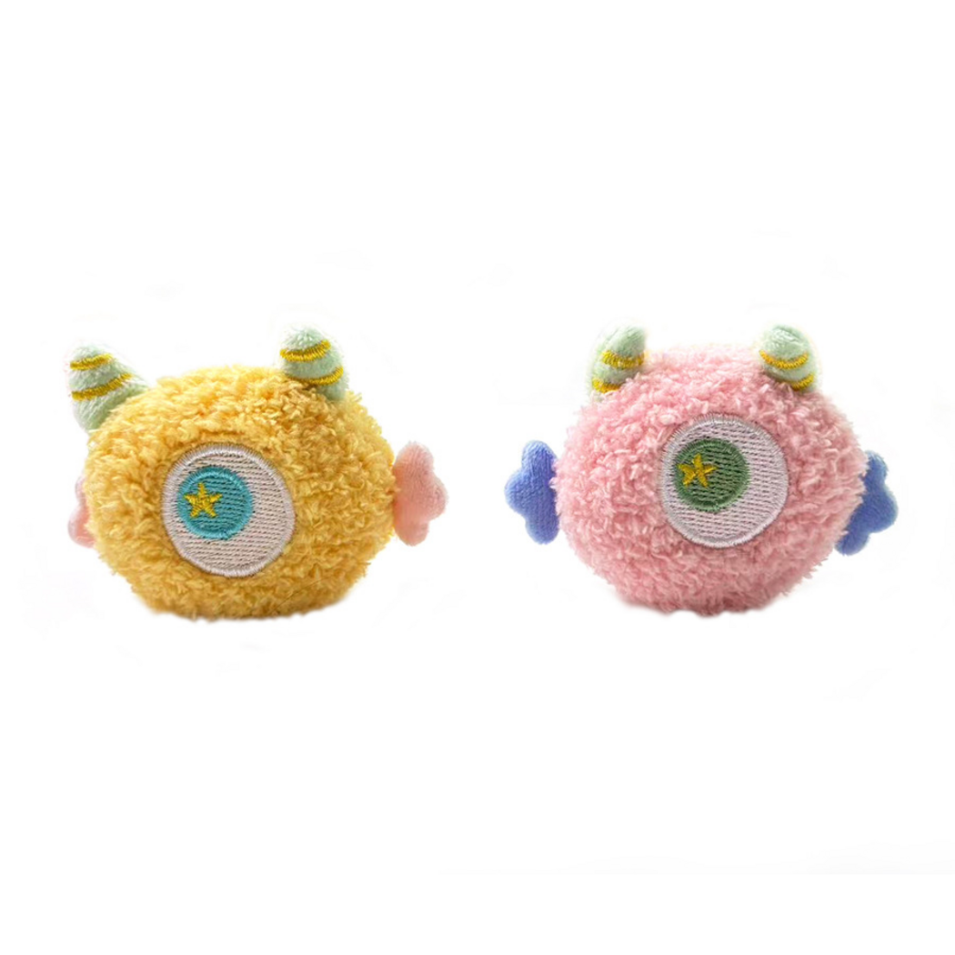 Yellow and Pink one-eyed cat toys standing side by side