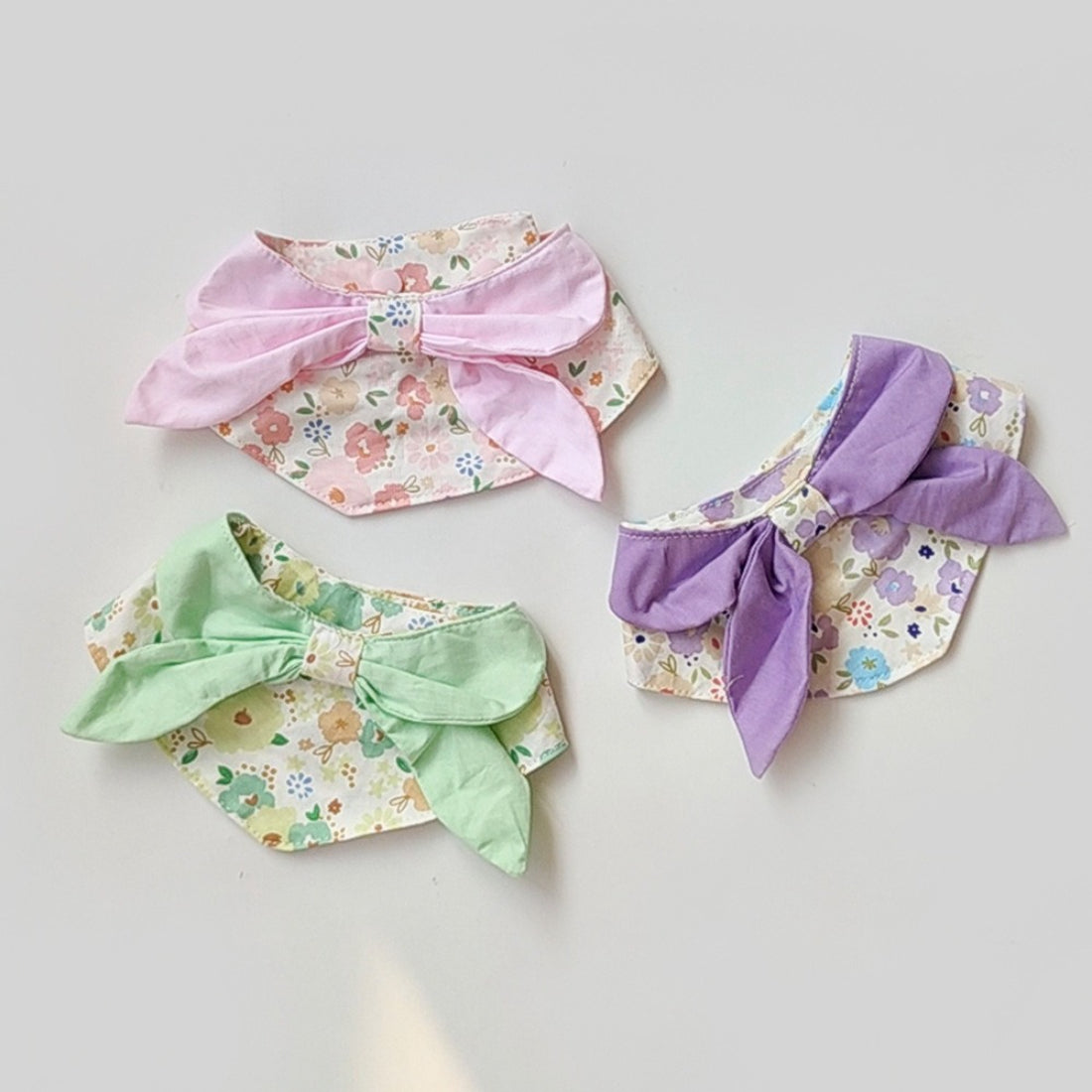 Mokka flower print cat neck bib displayed flat showing floral pattern