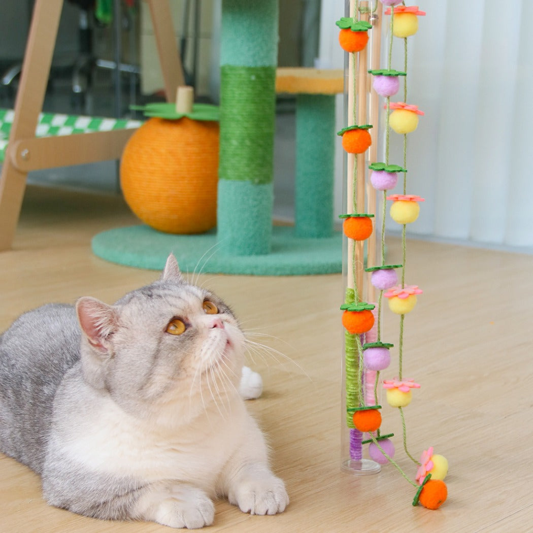 Close-up of Moo Hanging Pom Wand showing vibrant pom poms attached to the wand
