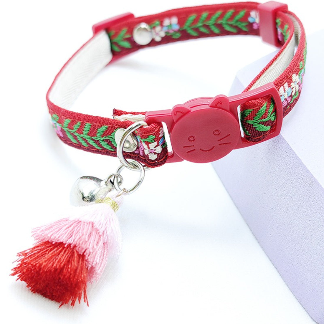 Close-up of Mokka cat collar showing floral pattern, tassel, and bell details