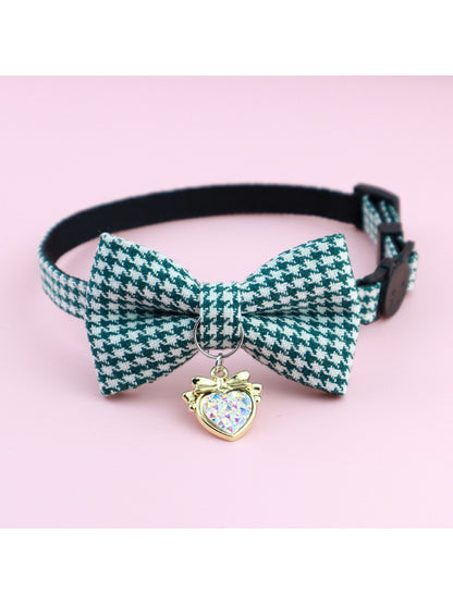 Close-up of bell attached to Mokka houndstooth bow cat collar