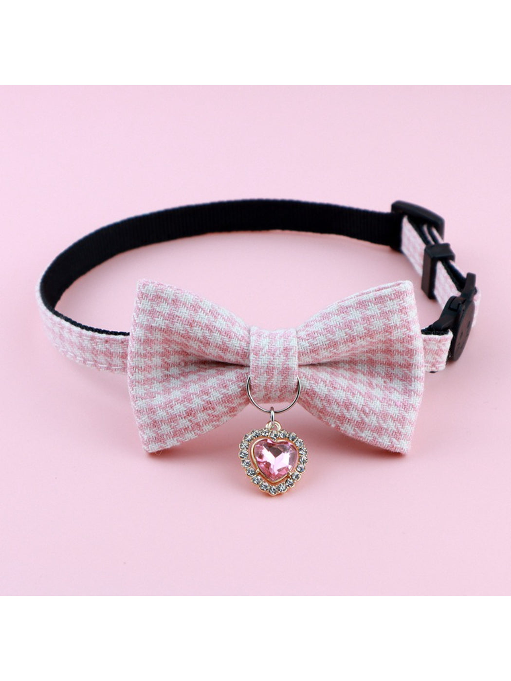 Mokka cat collar featuring a bow and bell displayed on a wooden surface