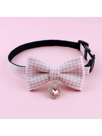 Mokka cat collar featuring a bow and bell displayed on a wooden surface