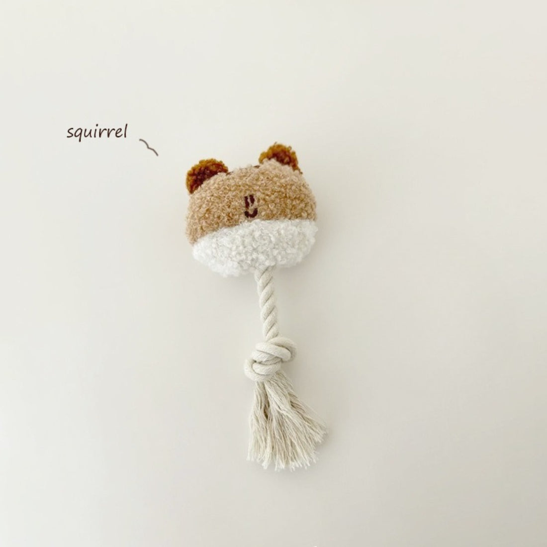 Petkin plush dog toy lying on white background with visible rope tail