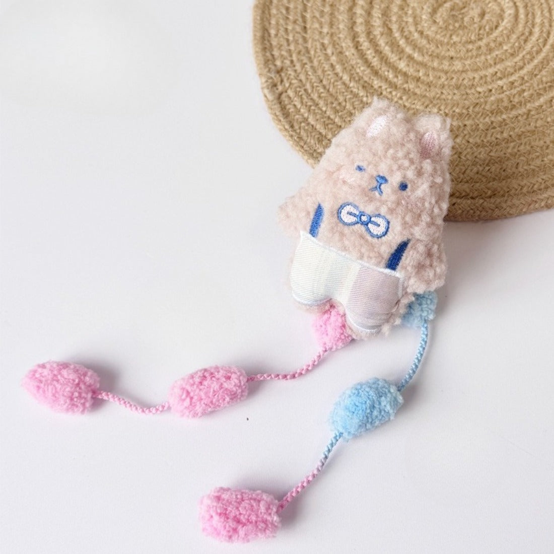 Moo plush cat toy held in hand to show size and interactive pom tail