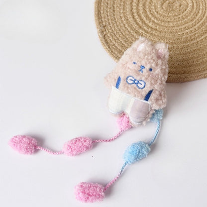 Moo plush cat toy held in hand to show size and interactive pom tail