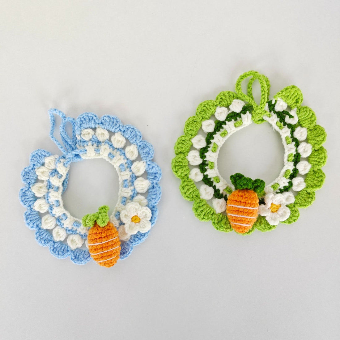 Close-up of Mokka crochet carrot cat collar with orange carrot charm and green leaves