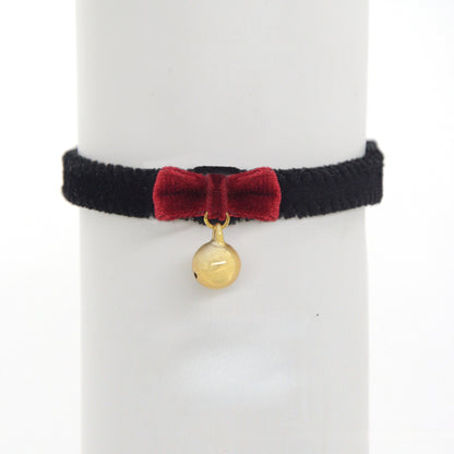 Close-up of black velvet cat collar showing adjustable strap and bell