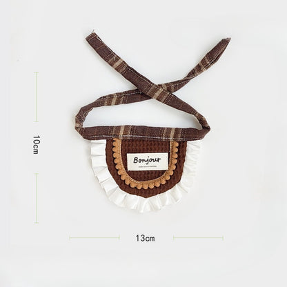 Brown ruffle cat bib folded neatly on a flat surface