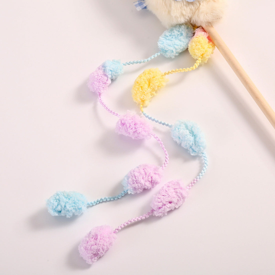 Side view of Moo plush cat teaser wand toy showing wooden stick and attached plush feathers