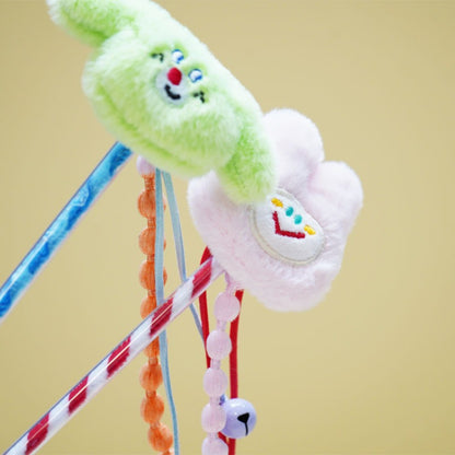 Moo plush cat teaser wand held by hand with beads visible