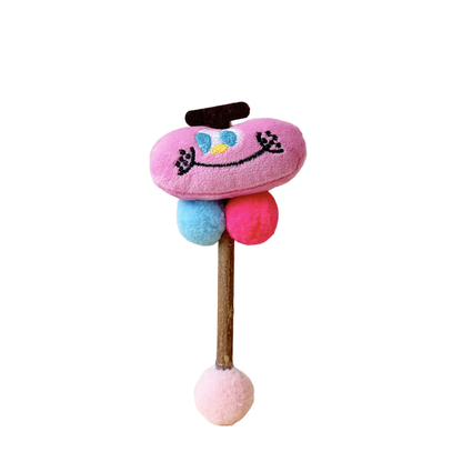 Pink Apple toy with a stitched smiling face, blue and pink balls, and a pale pink ball at the end of its stick.