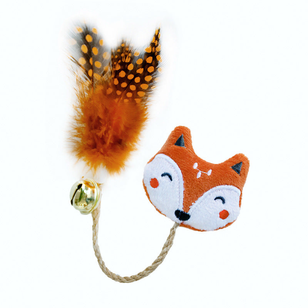 Fox cat toy with an embroidered face, braided cord, gold-colored bell and orange spotted feathers on a white background.