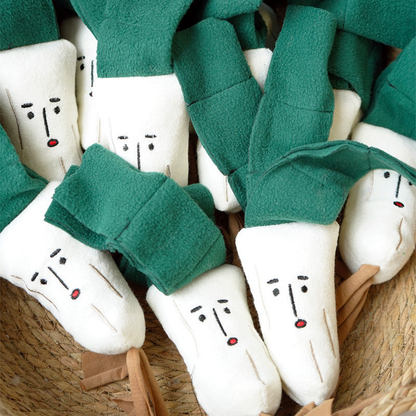 Scallion-shaped plush dog toys arranged in a woven basket