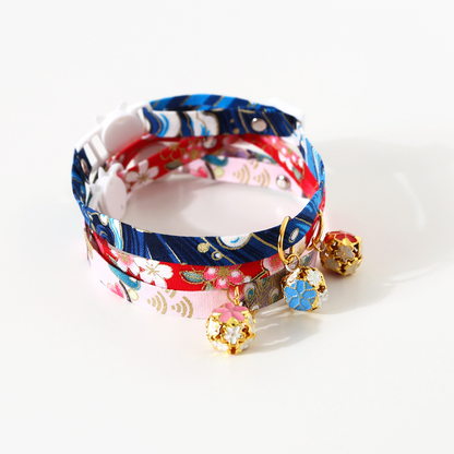 Three floral cat collars displayed together with decorative bells