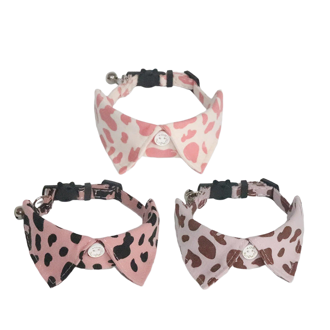 Three cow-print pointed cat collars displayed together