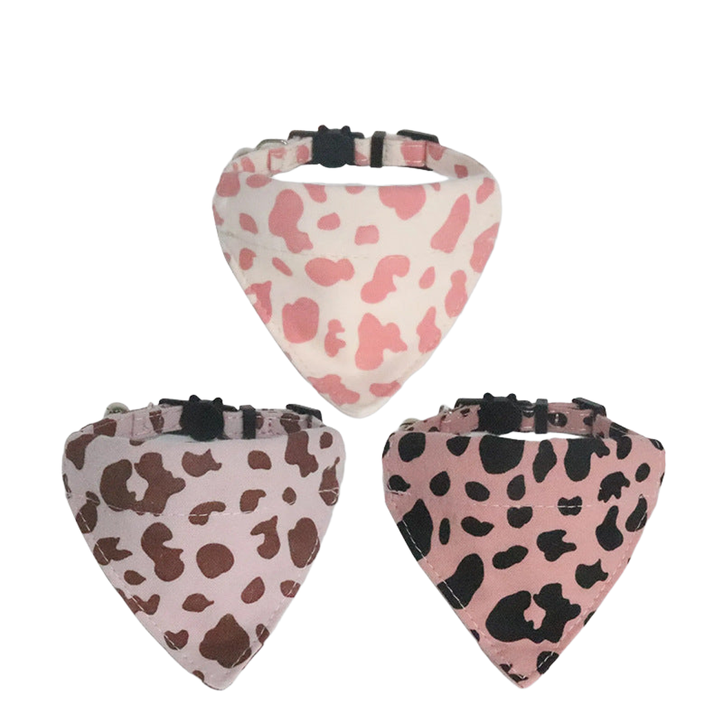 Three cow-print bandana cat collars displayed together
