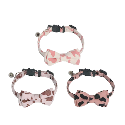 Three cow-print bow tie cat collars displayed together