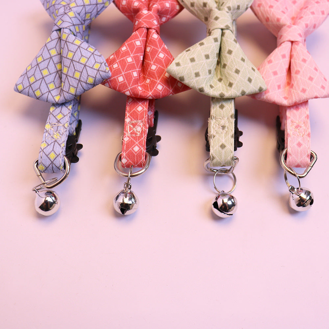 Close-up of silver-tone bells and rings on four patterned cat collars