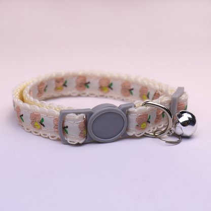 White cat collar with pink apple pattern, gray buckle and bell