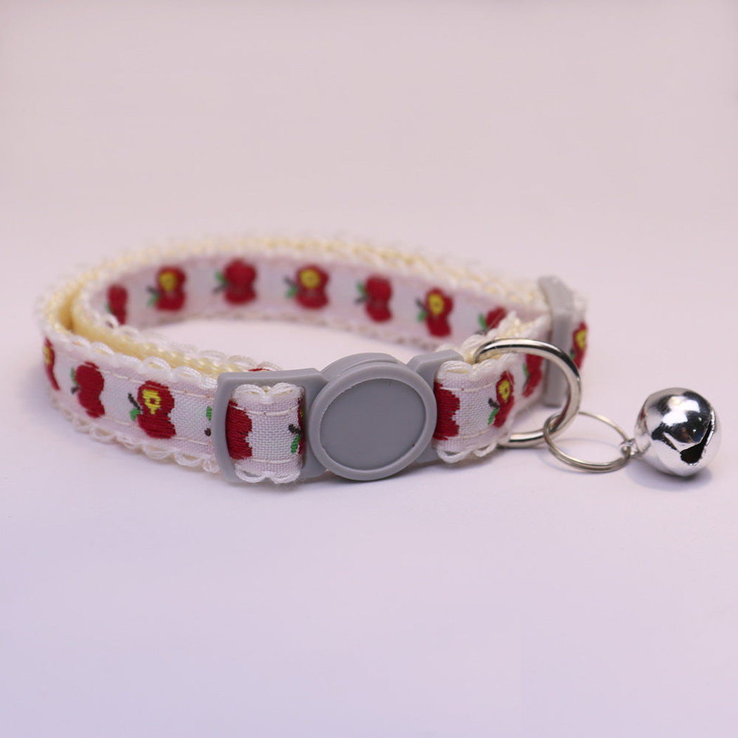 White cat collar with red apple pattern, gray buckle and bell