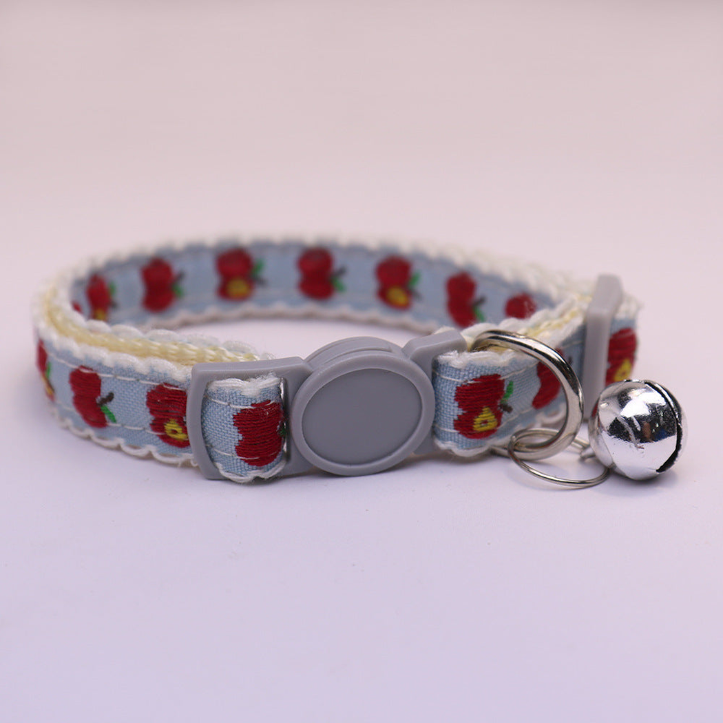 Light blue cat collar with red apple pattern, gray buckle and bell