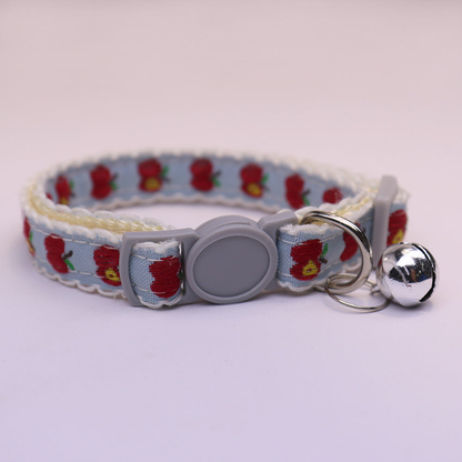 Light blue cat collar with red apple pattern, gray buckle and bell