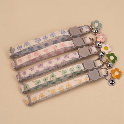 Five floral cat collars with bells and flower charms displayed together