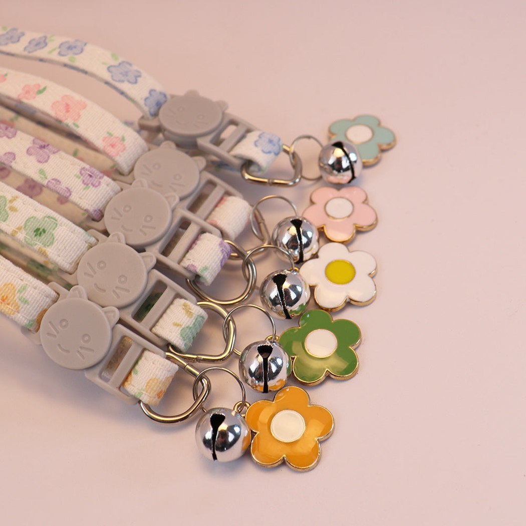 Close-up of cat-face buckles, silver-tone bells and flower charms