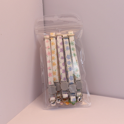 Five floral cat collars arranged together in clear retail packaging