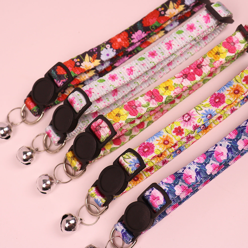 Five floral cat collars arranged diagonally with buckles and bells
