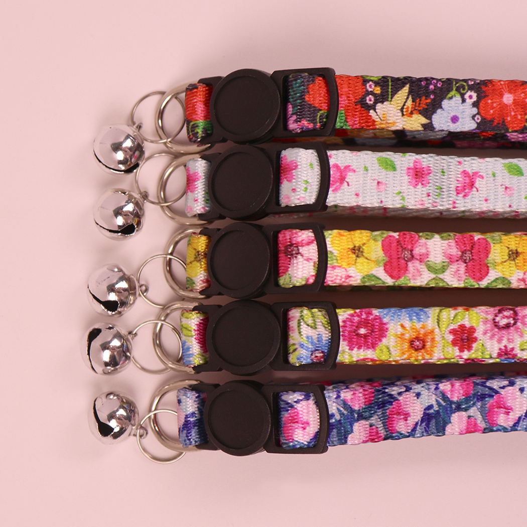 Close-up of floral collar buckles, split rings and silver-tone bells