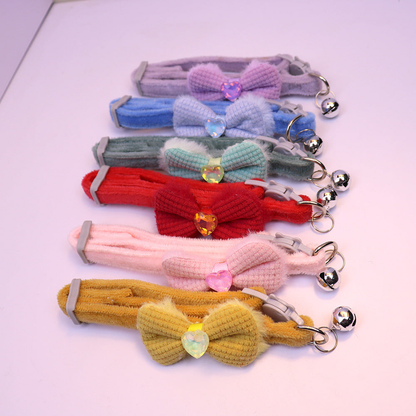 Six bow cat collars in assorted colors arranged together