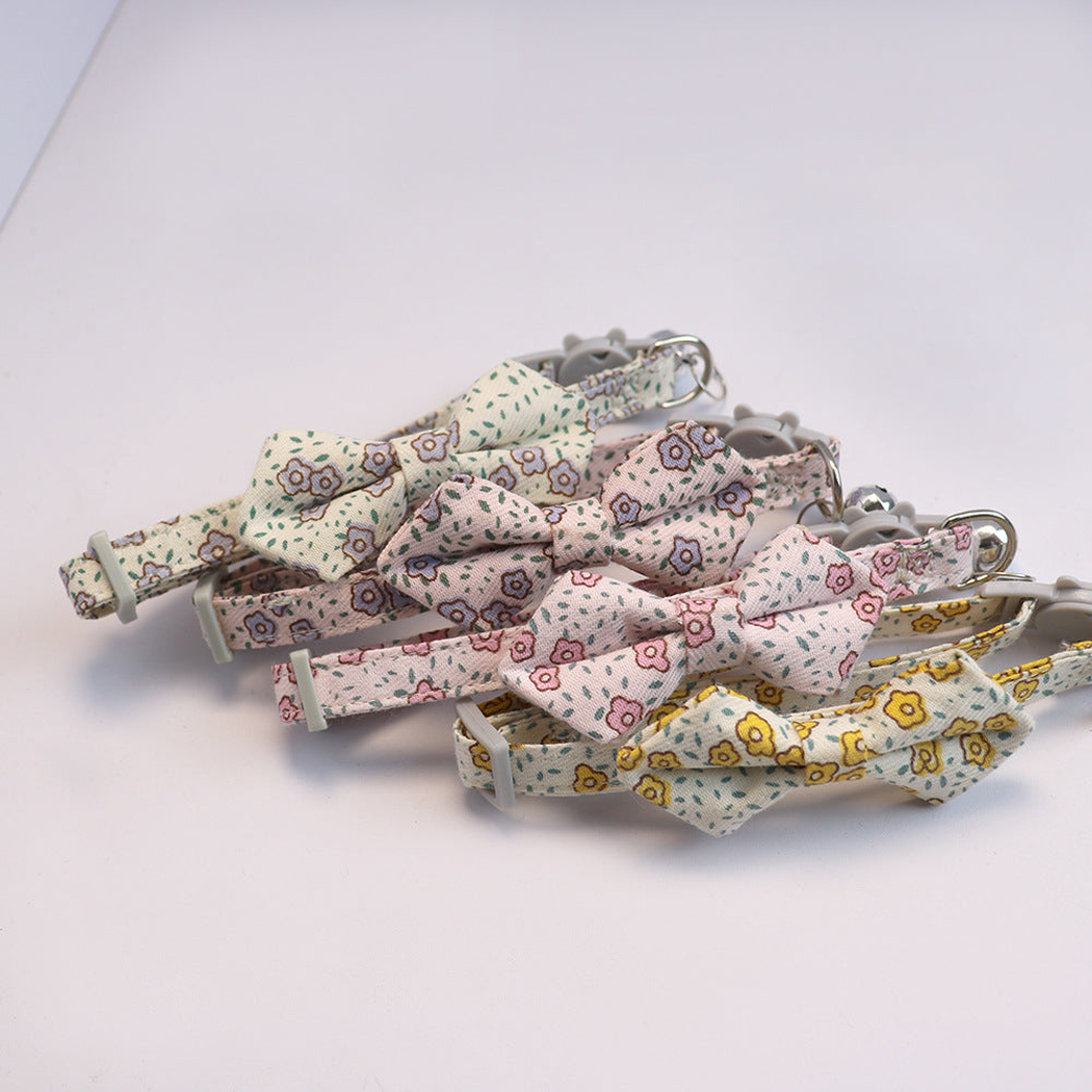 Four floral bow cat collars arranged together with bells and buckles visible