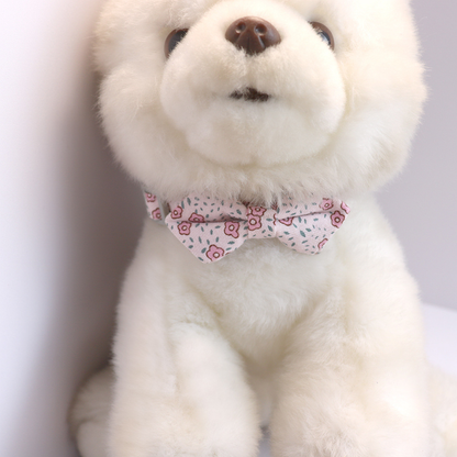 Light pink floral bow cat collar displayed on a plush animal model