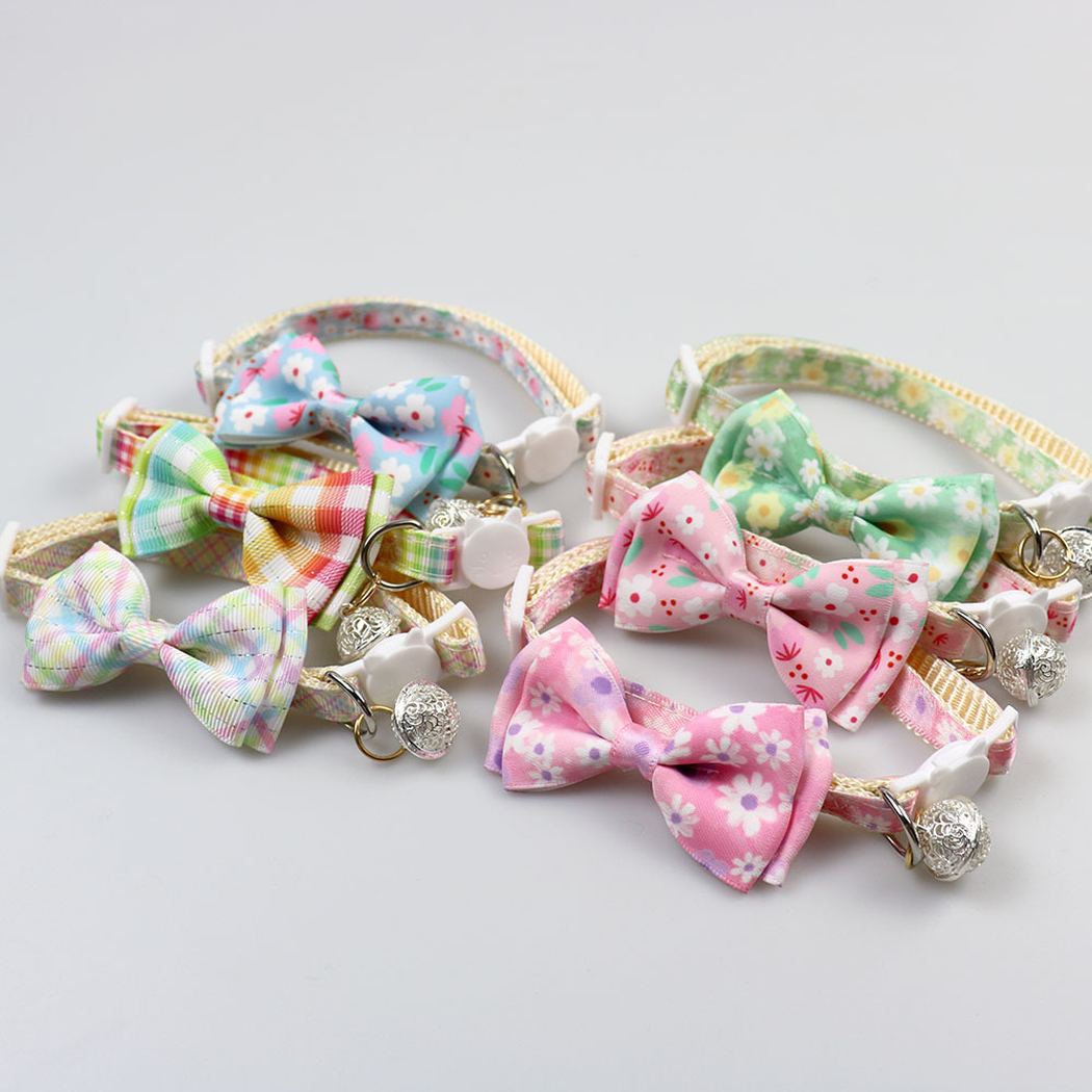 Assorted floral and plaid bow cat collars in an angled group display