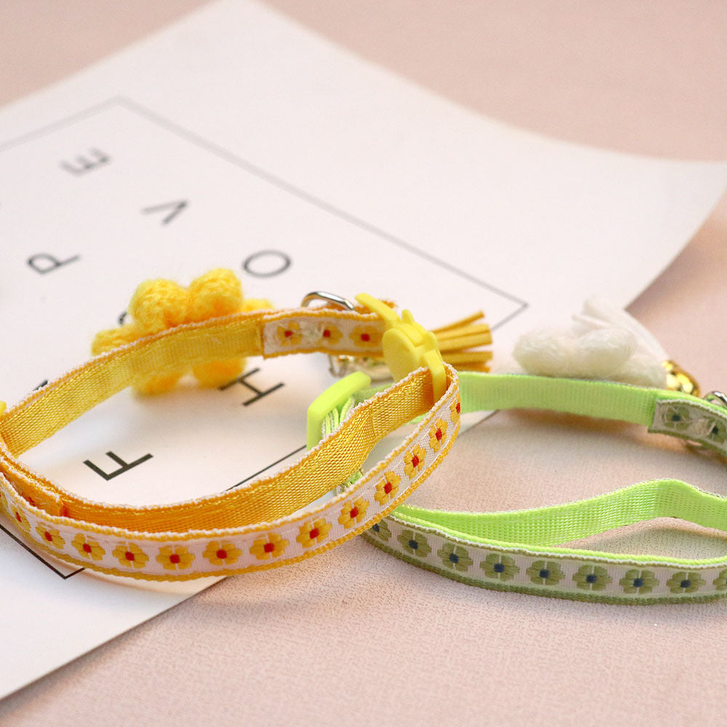 Close-up of yellow and green cat collar straps with floral bands and solid-color inner faces