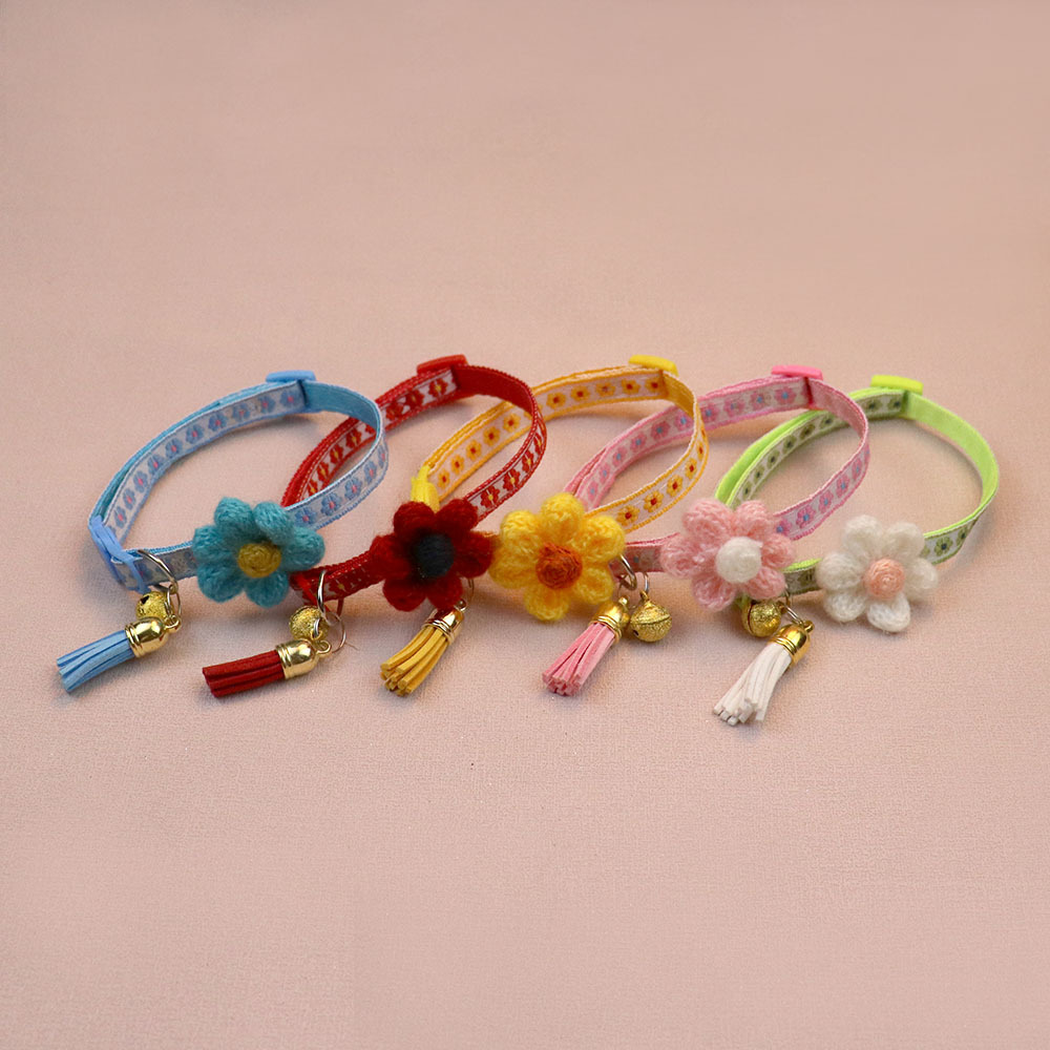 Five floral cat collars standing in a row with coordinated flowers and tassels