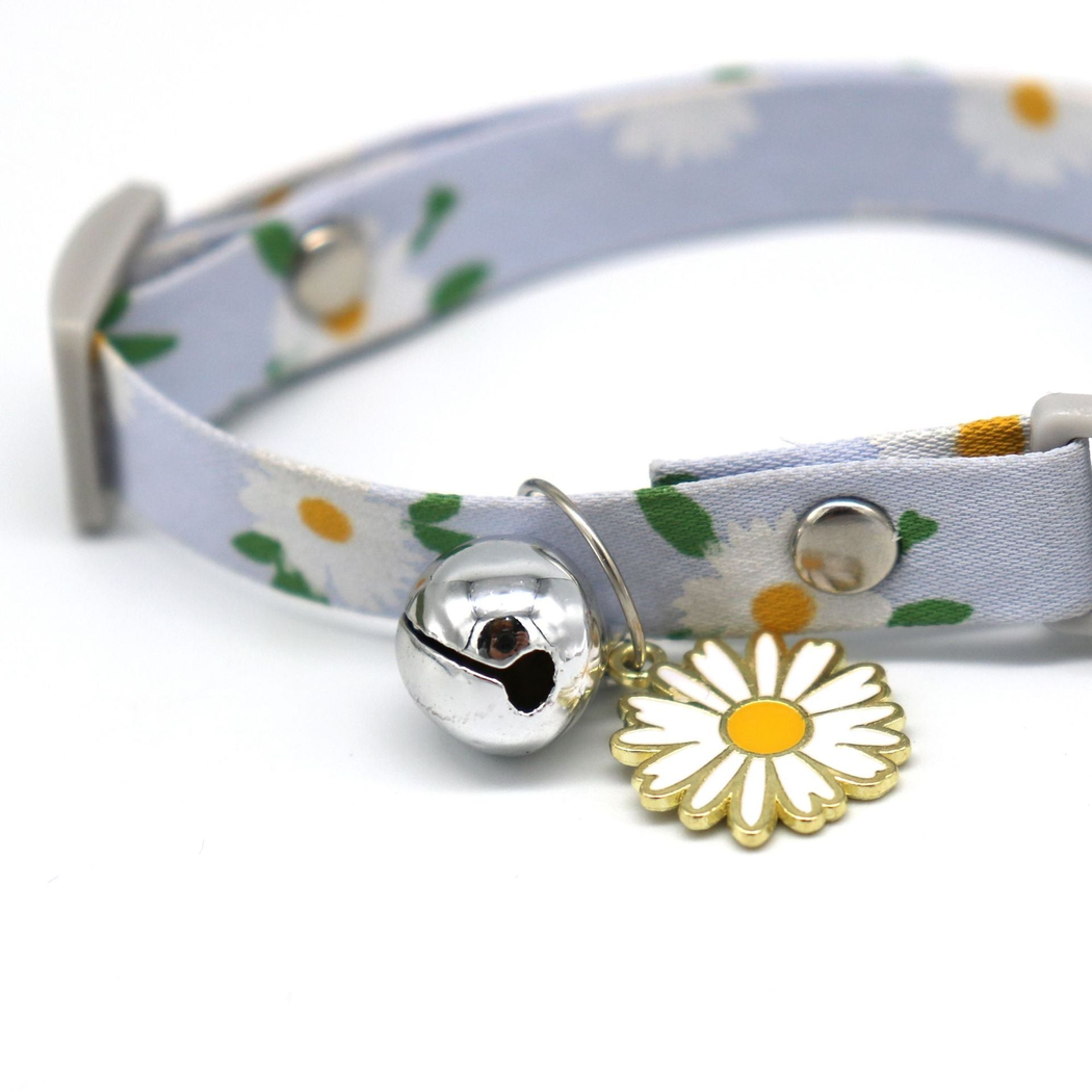 Close-up of the silver-tone bell and daisy charm on the collar