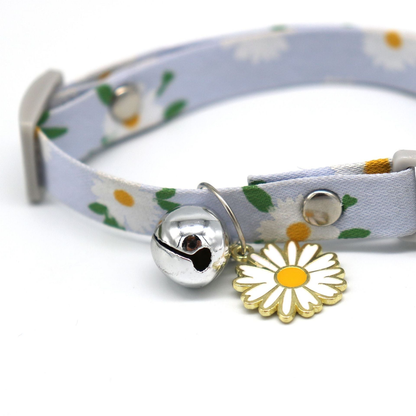 Close-up of the silver-tone bell and daisy charm on the collar