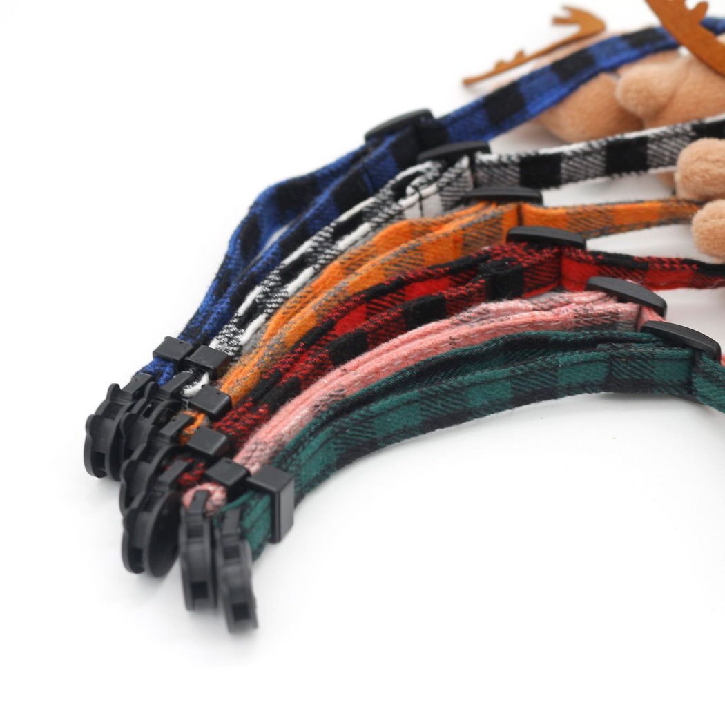 Close-up of plaid cat collar straps with black buckles and adjustment sliders