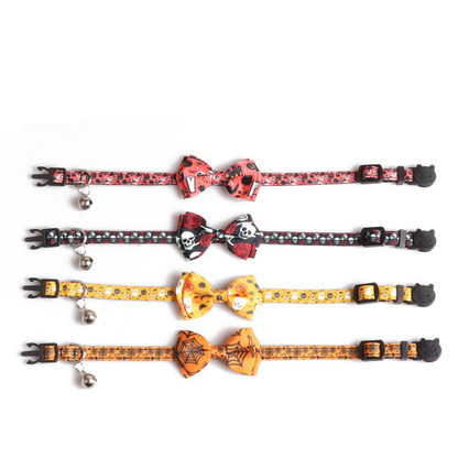 Four Halloween-print bow cat collars laid flat to show the buckles, sliders and bells