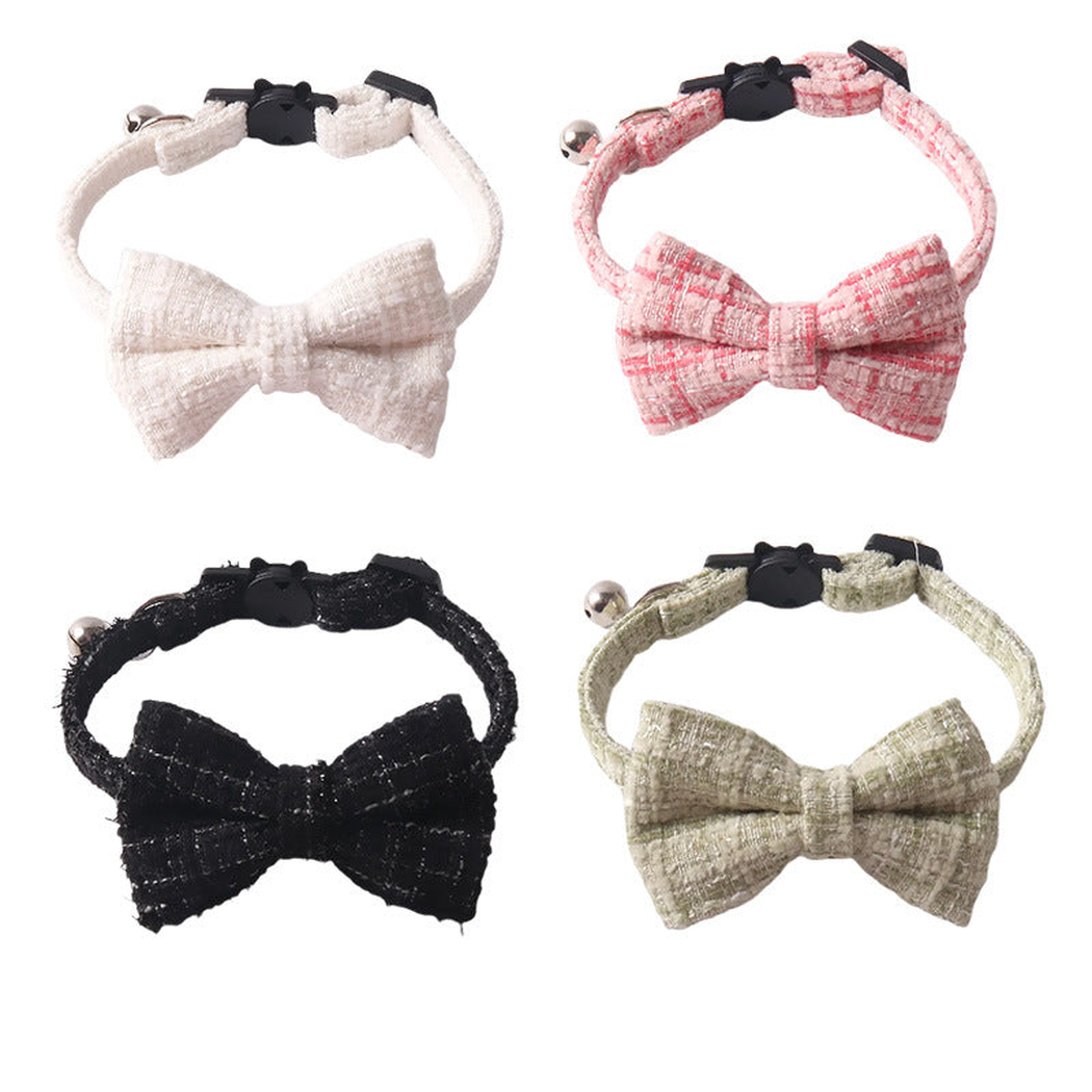 Pink, white, black and green bow cat collars displayed together