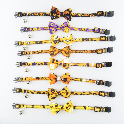 Eight Halloween cat collars laid flat in assorted bow and printed styles