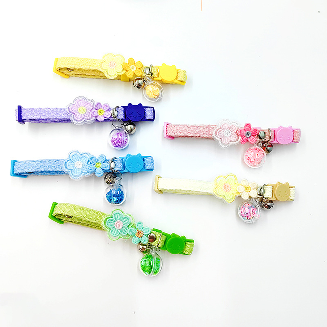 Six colorful flower cat collars arranged flat with buckles, bells and clear charms visible