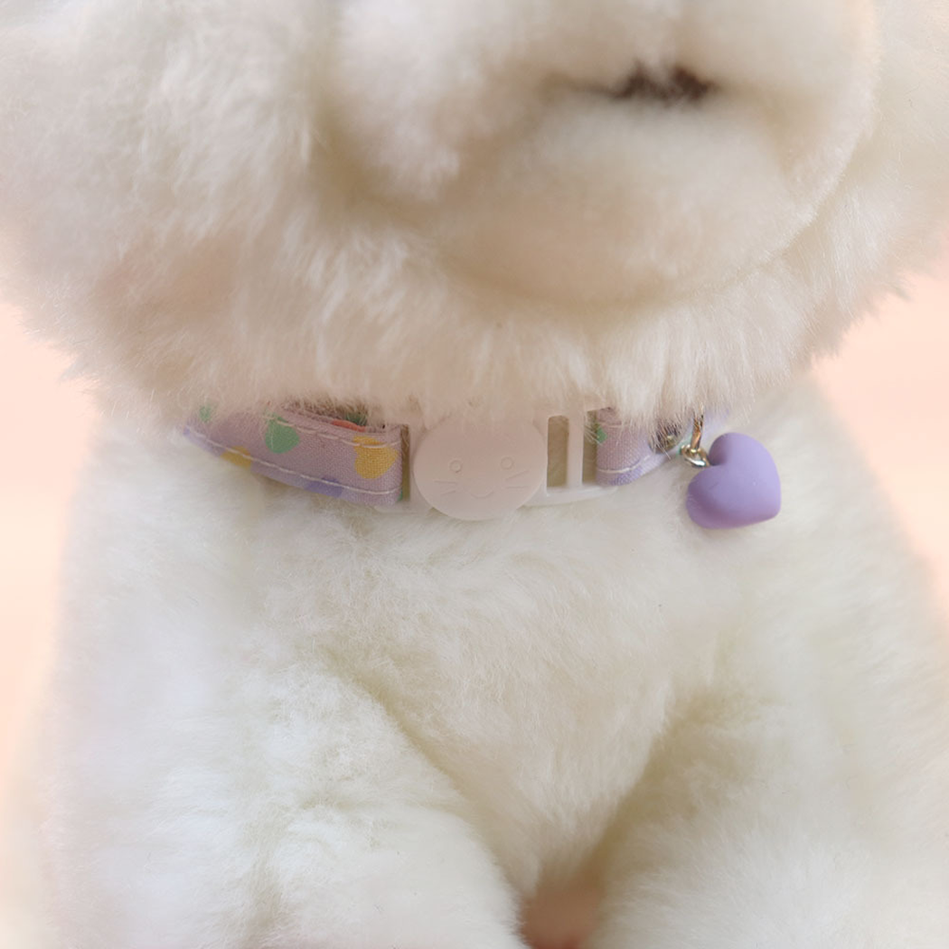 Light purple heart-print cat collar worn with the cat-face buckle centered and heart charm hanging to one side