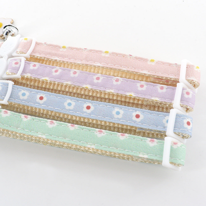 Close-up of daisy-patterned collar straps with stitched edges and sliding adjusters